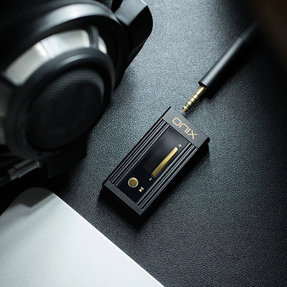 ONIX Alpha XI1 on black leather with a 4.4mm balanced headphone plug and over-ear headphones